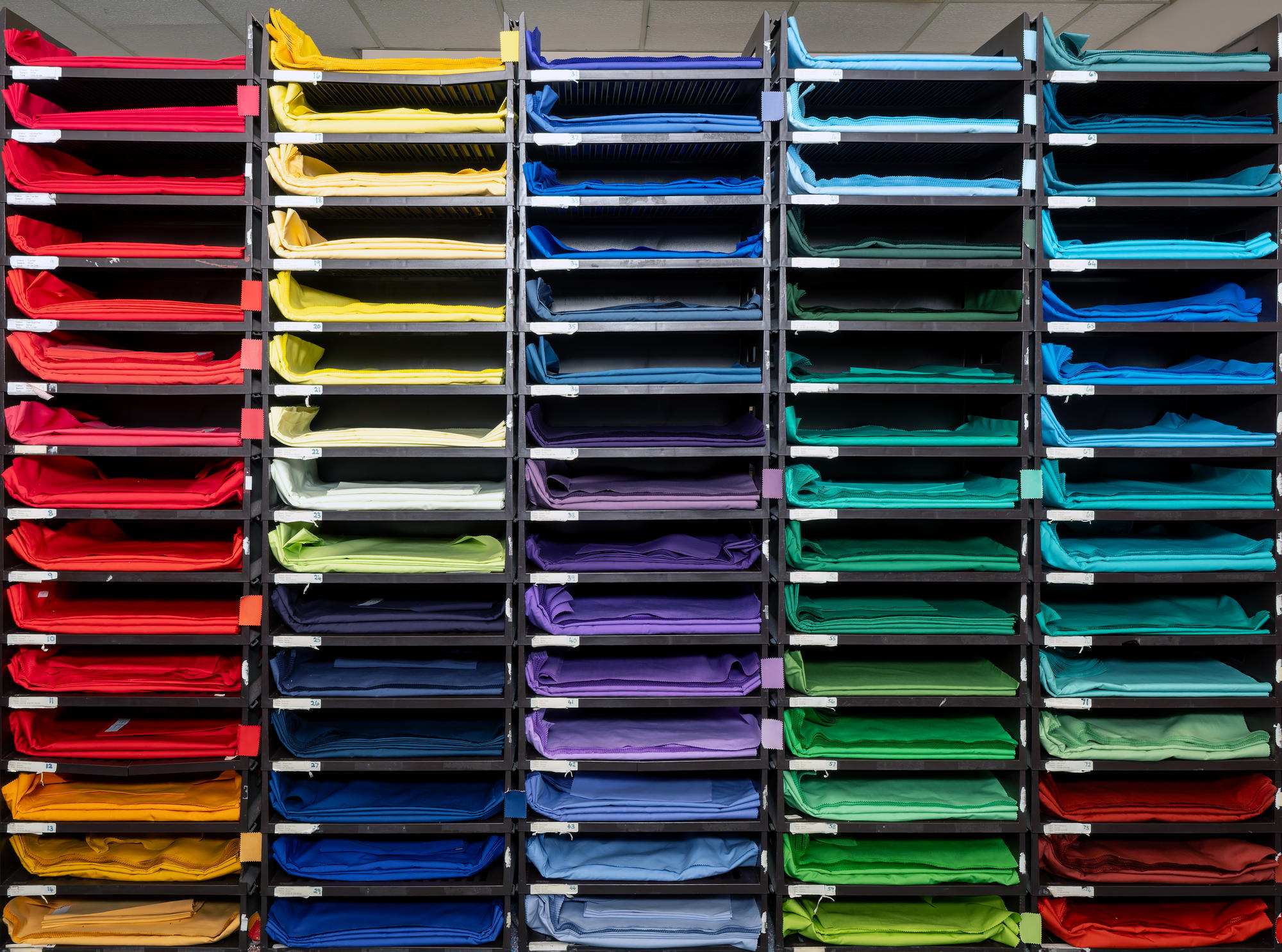 Shelves with different coloured drapes on each shelf
