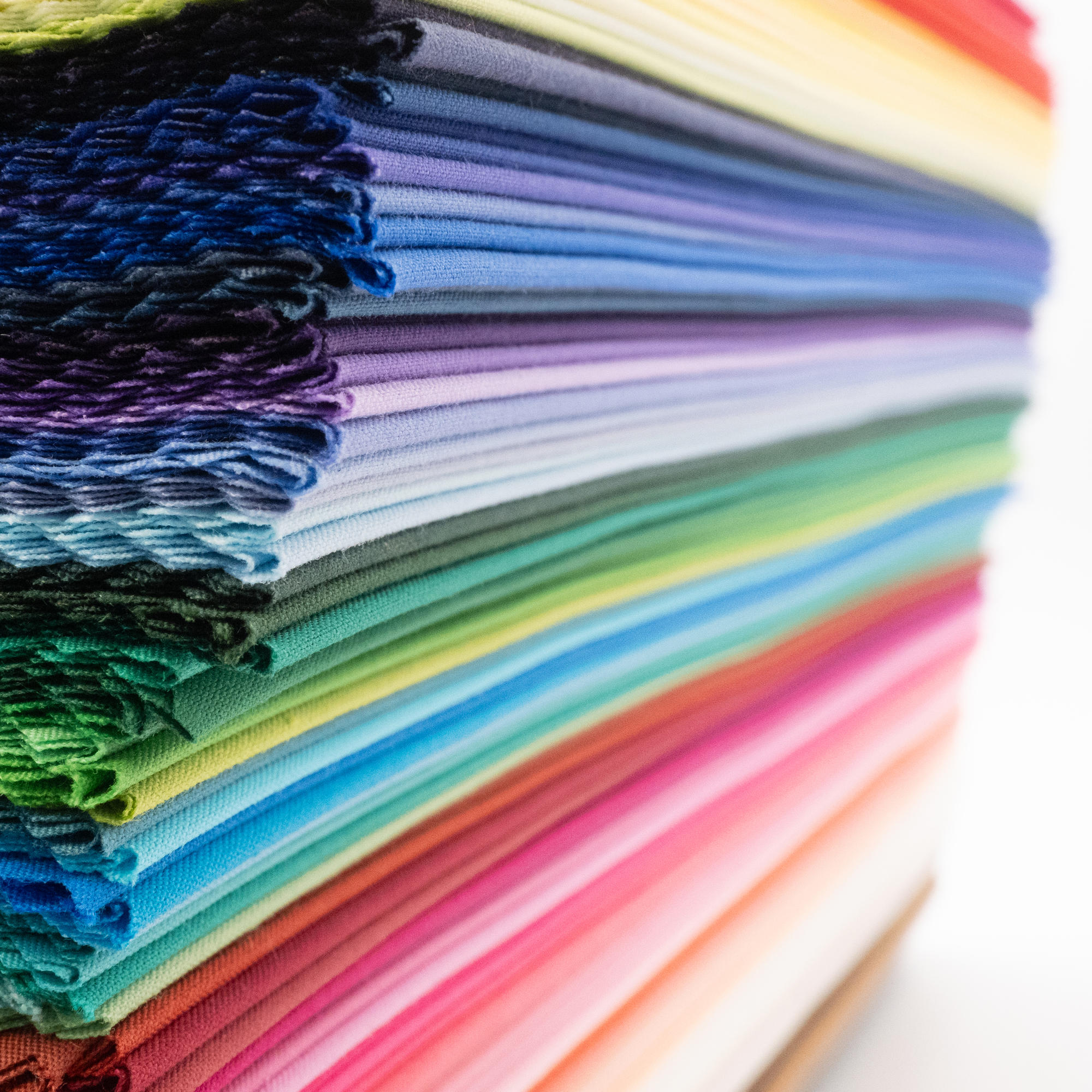 Close up of neat stack of all colours of direct colour drapes